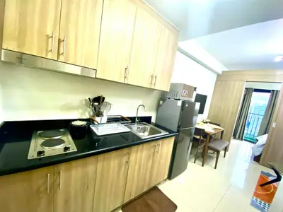 a kitchen with a sink and a refrigerator at Jay's Staycation at Shore Residences Pasay in Manila