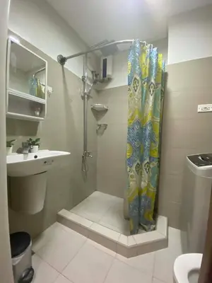 a shower curtain in a bathroom with a sink at Jay's Staycation at Shore Residences Pasay in Manila
