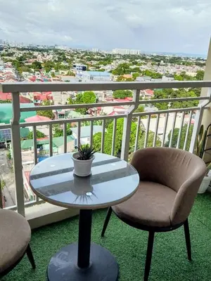 a table and chairs on a balcony with a view at The Atherton Condominium 1 Bedroom Staycation in Manila