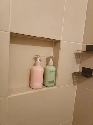 two bottles ofodorizers sitting on a shelf in a bathroom at The Atherton Condominium 1 Bedroom Staycation in Manila