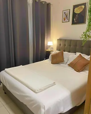 a bedroom with a large bed with white sheets at Staycation in Pasay near Moa in Manila