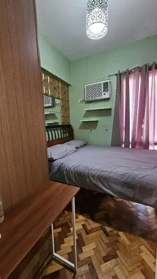 a room with two beds and a bench in it at Condotels by Macobs in Manila
