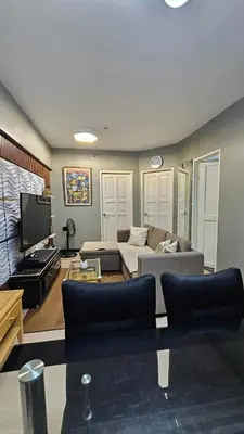 a living room with a couch and a flat screen tv at Condotels by Macobs in Manila