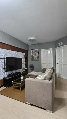 a living room with a couch and a flat screen tv at Condotels by Macobs in Manila