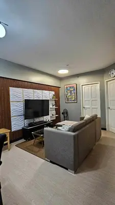 a living room with a couch and a flat screen tv at Condotels by Macobs in Manila