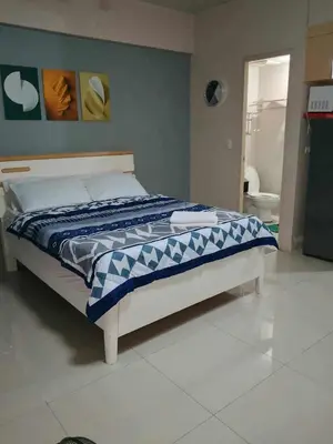 a bedroom with a bed and a bathroom at Neri Ann's Comfort Escape in Manila
