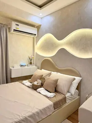 a bedroom with a large bed with two baskets on it at Midhaven Suite in Manila