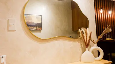 a bathroom with a mirror and a vase on a sink at Midhaven Suite in Manila