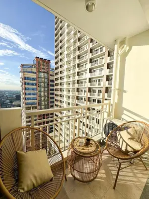 a balcony with chairs and tables on a building at Midhaven Suite in Manila