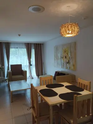 a living room with a table and a dining room at Manila Southwoods Manor in Carmona