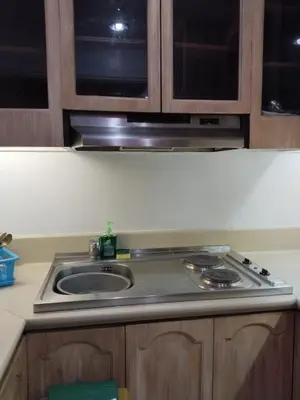 a kitchen counter with a sink and a stove at Manila Southwoods Manor in Carmona