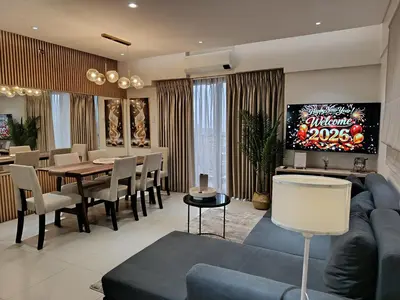 a living room with a blue couch and a dining room at Casa Alea Serenity by TinTan - Cozy 3BR Condo Unit in Manila