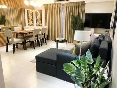 a living room with a blue couch and a table at Casa Alea Serenity by TinTan - Cozy 3BR Condo Unit in Manila