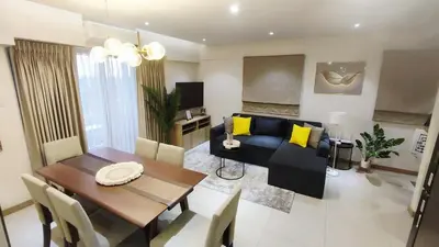 a living room with a table and a blue couch at Casa Alea Serenity by TinTan - Cozy 3BR Condo Unit in Manila