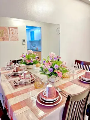 a dining room table with plates and flowers on it at 1 Bedroom Unit terminal 3 Airport By ASD Condotel in Manila