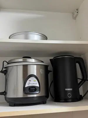 a slow cooker and a toaster sitting on a shelf at 1 Bedroom Unit terminal 3 Airport By ASD Condotel in Manila