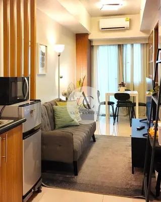 a living room with a couch and a kitchen at Cozy staycation 1BR with WiFi, Netflix and more at Shore 3 MOA by Angels Cozy Corner in Manila