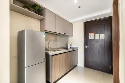 a kitchen with a refrigerator and a sink and a door at Elegant Studio City View near Airport, City of Dreams, Okada, Solaire, PARQAL, Ayala Malls, and MOA in Manila
