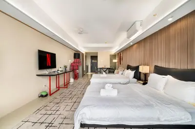a hotel room with two beds and a television at Elegant Studio City View near Airport, City of Dreams, Okada, Solaire, PARQAL, Ayala Malls, and MOA in Manila