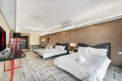 a hotel room with two beds and a desk at Elegant Studio City View near Airport, City of Dreams, Okada, Solaire, PARQAL, Ayala Malls, and MOA in Manila