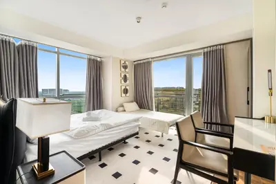 a hotel room with a bed and a window at Elegant 2BR City View near City of Dreams, Okada, Solaire, PARQAL, Ayala Malls, MOA, and Airport in Manila
