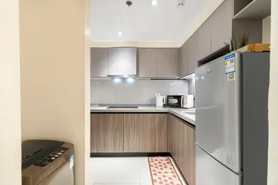 a kitchen with a white refrigerator and wooden cabinets at Elegant 2BR City View near City of Dreams, Okada, Solaire, PARQAL, Ayala Malls, MOA, and Airport in Manila