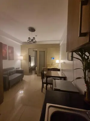 a living room with a couch and a dining room at Cozy Bedroom at SM MOA Sunset View by Manila Bay in Manila