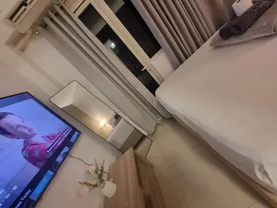 a flat screen tv in a room with a window at Cozy Bedroom at SM MOA Sunset View by Manila Bay in Manila
