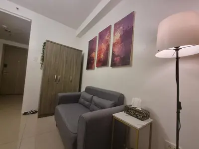 a living room with a couch and a lamp at Cozy Bedroom at SM MOA Sunset View by Manila Bay in Manila