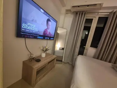 a room with a television on the wall with a bed at Cozy Bedroom at SM MOA Sunset View by Manila Bay in Manila