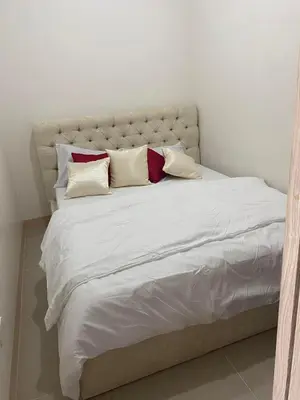 a large white bed with four pillows on it at Leaf Residences in Muntinlupa