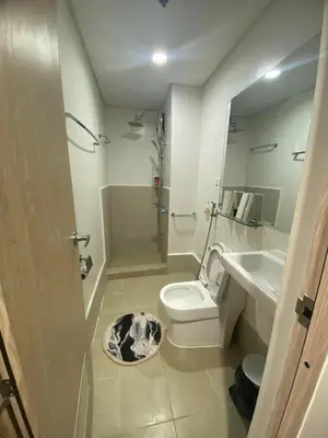 a bathroom with a toilet and a sink and a mirror at Leaf Residences in Muntinlupa