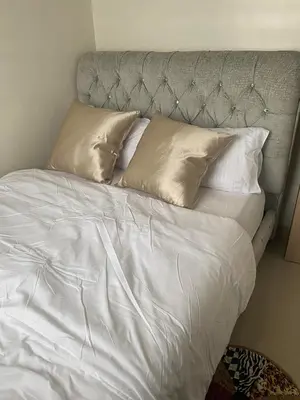a bed with white sheets and pillows at 2 bedroom condo at Leaf Residences Muntinlupa in Manila