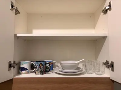 a cupboard with plates and cups on a shelf at New 1BR Condo at The Camden Place Near DLSU Manila in Manila