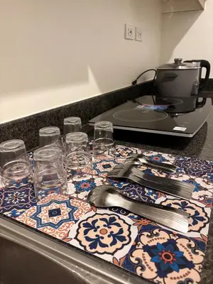 a table with glasses and a printer on a counter at New 1BR Condo at The Camden Place Near DLSU Manila in Manila