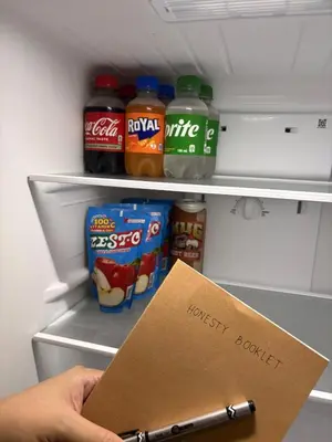 a person holding a sign in front of an open refrigerator at New 1BR Condo at The Camden Place Near DLSU Manila in Manila