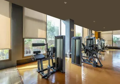 a gym with a row of treadmills and exercise bikes at Bayfront Suite in Pasay, With Balcony, Manila Bay View, Near MOA, OKADA, PICC, Airport, WFH ready Free pool access Gym and Sauna in Manila