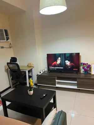 a living room with a flat screen tv on a wall at Bayfront Suite in Pasay, With Balcony, Manila Bay View, Near MOA, OKADA, PICC, Airport, WFH ready Free pool access Gym and Sauna in Manila