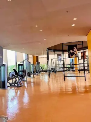 a large room with a wooden floor and a large mirror at Family Condotels by Gerry in Manila