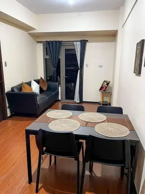 a living room with a table and chairs and a couch at Family Condotels by Gerry in Manila