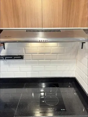 a silver stove top in a kitchen with white tiles at Family Condotels by Gerry in Manila