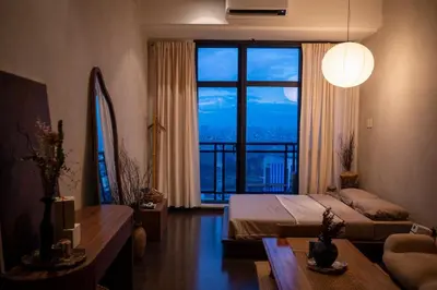 a bedroom with a bed and a large window at Wabi-Sabi Stay at Knightsbridge Residences in Manila
