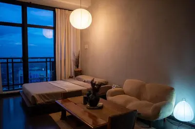 a living room with a bed and a couch and a table at Wabi-Sabi Stay at Knightsbridge Residences in Manila