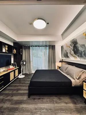 a bedroom with a large bed and a television at Azure Residence by Ibiza Homes in Manila