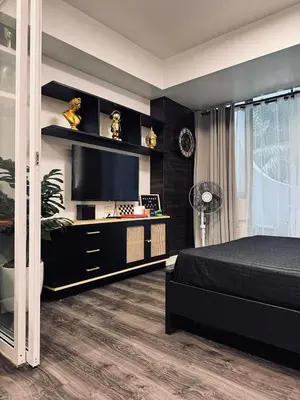 a bedroom with a bed and a flat screen tv at Azure Residence by Ibiza Homes in Manila