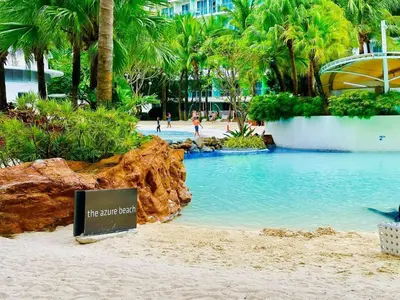 a resort swimming pool with a sign on the beach at Azure Residence by Ibiza Homes in Manila
