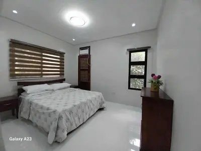 a white bedroom with a bed and a window at Sehaliah Agricultural Farm Resort in Amadeo