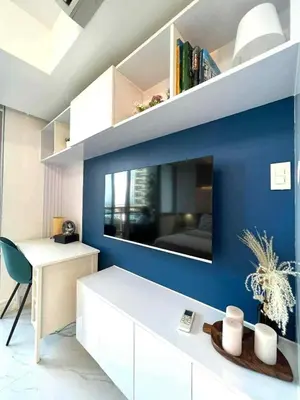 a living room with a large tv on a blue wall at Guest House Ground Zero in Manila