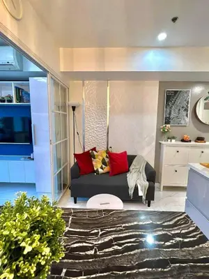 a living room with a black couch and red pillows at Guest House Ground Zero in Manila