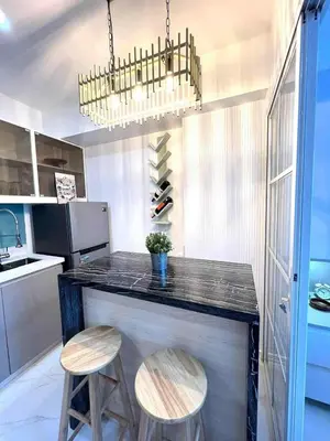 a kitchen with a counter with two stools and a bar at Guest House Ground Zero in Manila